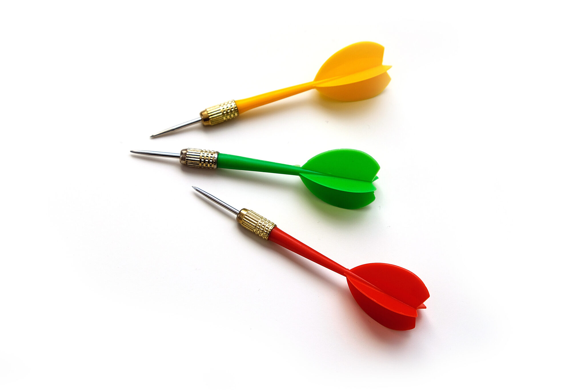 red, green and yellow colored dart arrow, on white ground,